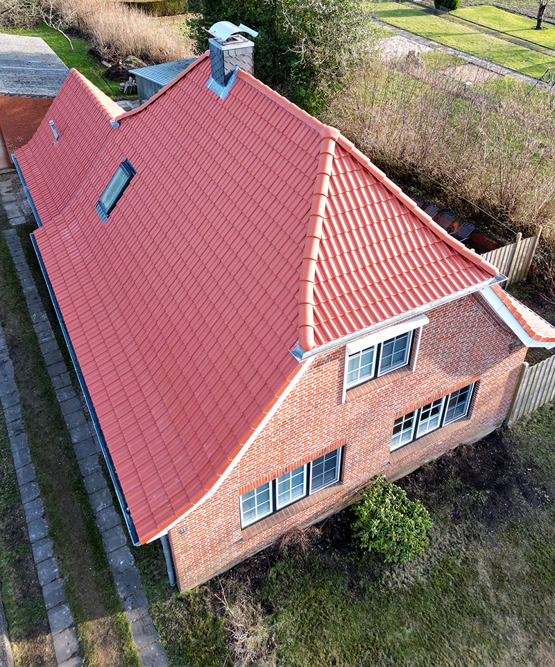 Dachdecker Itzehoe - Komplett sanierte Dacheindeckung mit roten Dachziegeln in Itzehoe