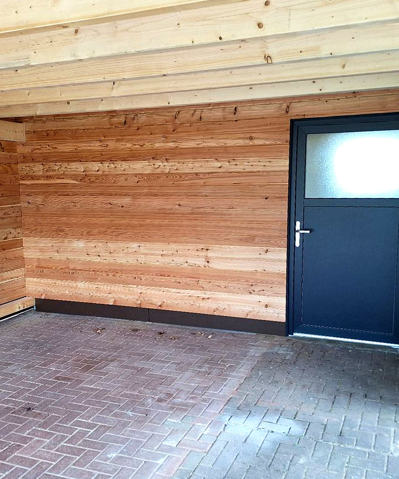 Zimmerei Kaltenkirchen – moderne Holzverkleidung mit Eingangstür, erstellt von der Zimmerei.